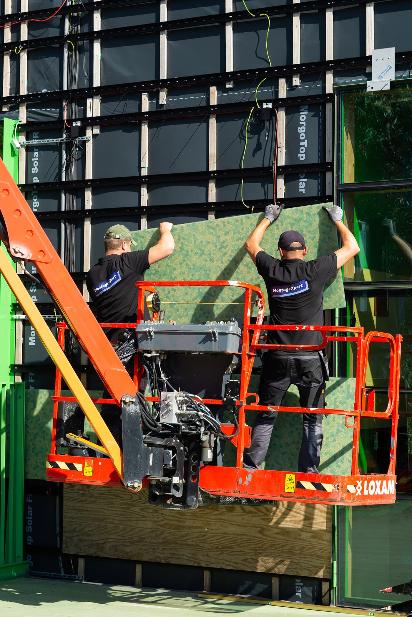Installatie gekleurde zonnepanelen op de gevel basisschool De Kikker | Dok Architecten | Solarix